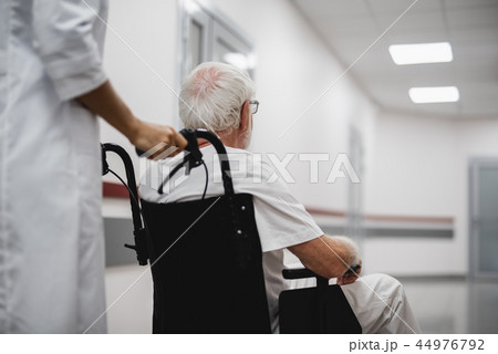 Doctor walking with disabled old man in hospital hallway 44976792