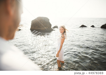 happy just married young wedding couple celebrating and have fun at beautiful beach sunset happy just married young wedding couple celebrating and have fun at beautiful beach sunset 44978369