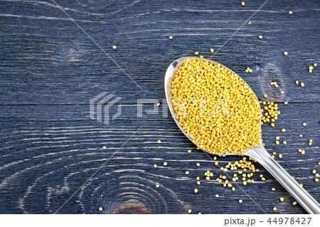 Mustard seeds in metal spoon on board top Mustard seeds in metal spoon on board top 44978427