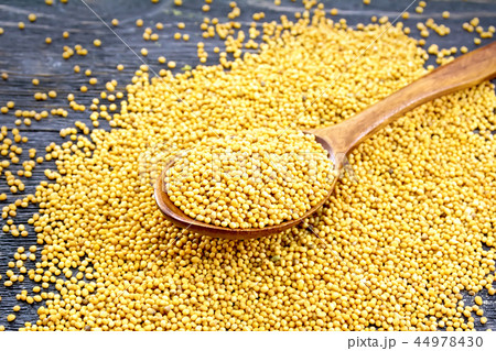 Mustard seeds in spoon on board Mustard seeds in spoon on board 44978430