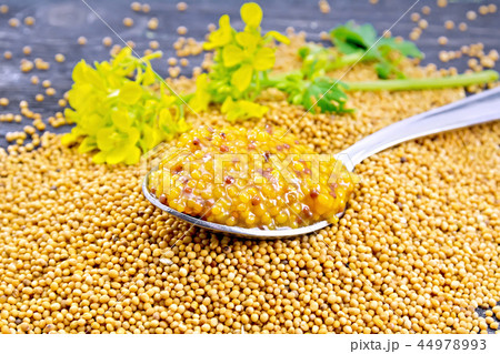 Sauce mustard Dijon in spoon with flower on board Sauce mustard Dijon in spoon with flower on board 44978993