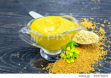 Sauce mustard in sauceboat with powder on board 44979005