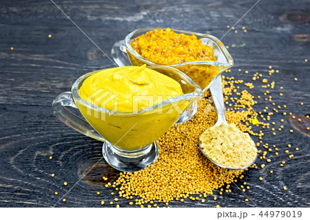 Sauce mustard in sauceboats with powder on board 44979019