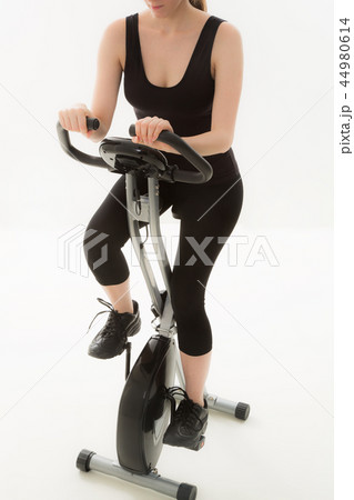 エアロバイクを漕ぐ若い女性 44980614
