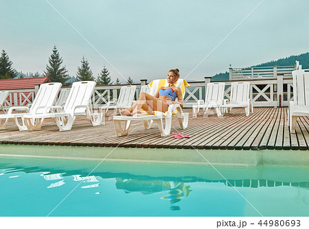 Woman relaxing on beach chair during summer vacation. 44980693