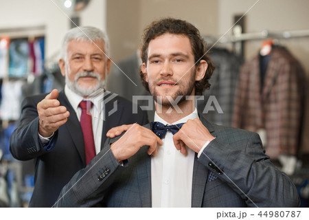 Two happy atractive elegant men choosing clothes for special occaision. Two happy atractive elegant men choosing clothes for special occaision. 44980787