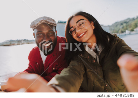 Happy couple relaxing and taking lovely selfies outdoors Happy couple relaxing and taking lovely selfies outdoors 44981988
