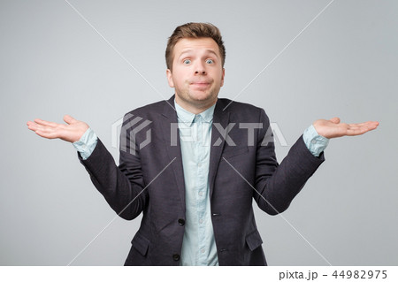 Young caucasian man in suit and white shirt is confused 44982975