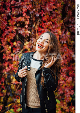 Beautiful stylish girl in leather jacket standing and posing in autumn park. Beautiful stylish girl in leather jacket standing and posing in autumn park. 44985796