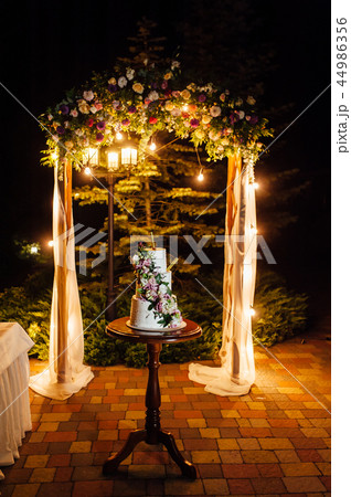 wedding cake three floors with fruit outside in the evening 44986356