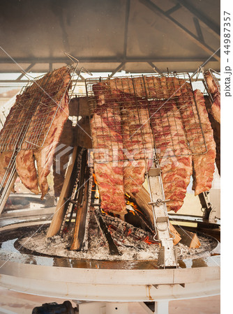 Roasted meat of beef cooked on a vertical grills. Roasted meat of beef cooked on a vertical grills. 44987357