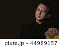 young man close up portrait, on black with glasses 44989157