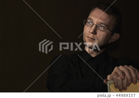 young man close up portrait, on black with glasses 44989157
