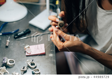 The girl works on a jewelry in the workshop The girl works on a jewelry in the workshop 44989729