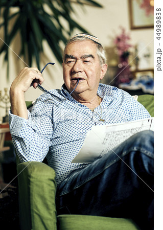 Pensive Jewish senior in the armchair reading a torah book Pensive Jewish senior in the armchair reading a torah book 44989838