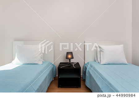 Modern bedroom with pillows and a bed for tourists. Frontally. Modern bedroom with pillows and a bed for tourists. Frontally. 44990984