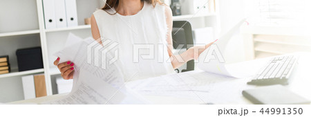 A young girl in the office looks through documents. 44991350