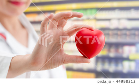Doctor holding a red heart at hospital office. 44998313