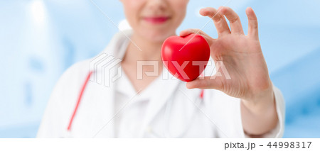 Doctor holding a red heart at hospital office. 44998317
