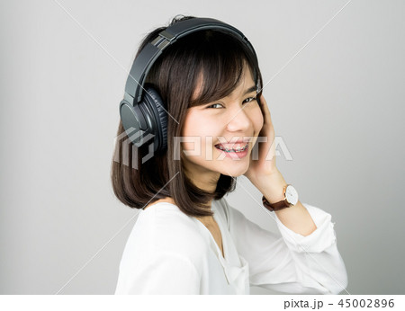girl in white casual dress listening to music. girl in white casual dress listening to music. 45002896