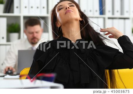 Beautiful smiling brunette woman in office tidying hair Beautiful smiling brunette woman in office tidying hair 45003675