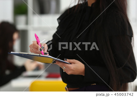 Brunette woman hold in arms pink pen and paper 45003742