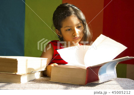 Little girl reading big books as if scholar, Pune 45005212