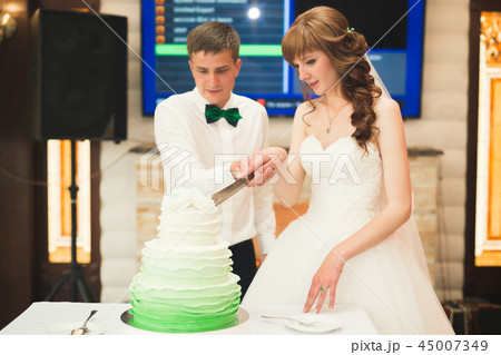 Bride and groom at wedding cutting the wedding cake 45007349