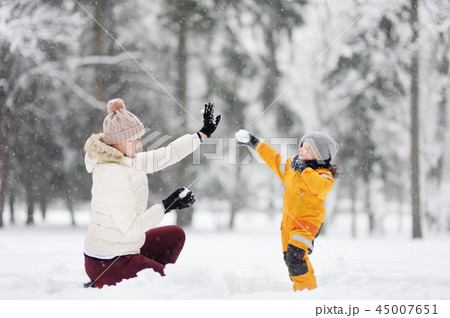 Little boy and mother playing snowballs Little boy and mother playing snowballs 45007651
