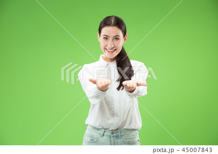 The happy business woman standing and smiling against green background. The happy business woman standing and smiling against green background. 45007843