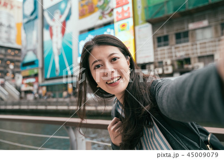 traveler taking selfie with runner sign in osaka 45009079