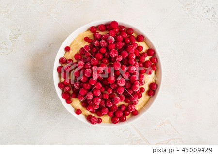 Cranberries adding to a sweet dough for muffins Cranberries adding to a sweet dough for muffins 45009429