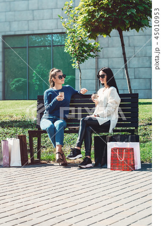 Beautiful girls with paper bags outside shopping mall 45010953