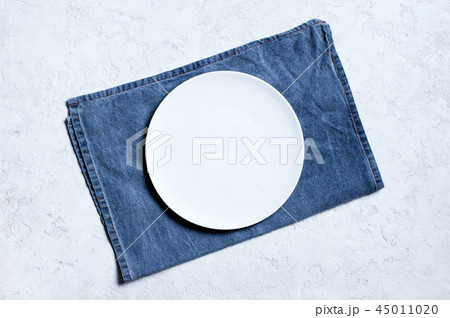 White plate on the blue denim napkin White plate on the blue denim napkin 45011020