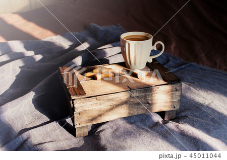 White cup of coffee on the bed White cup of coffee on the bed 45011044