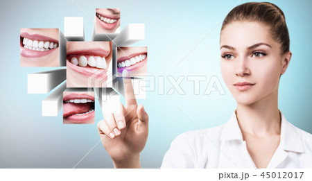 Dentist doctor pointing with finger on collage of healthy beautiful smiles. 45012017