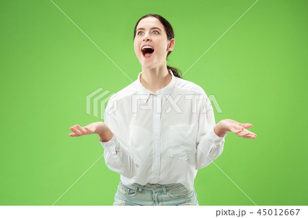 Beautiful woman looking suprised isolated on green Beautiful woman looking suprised isolated on green 45012667