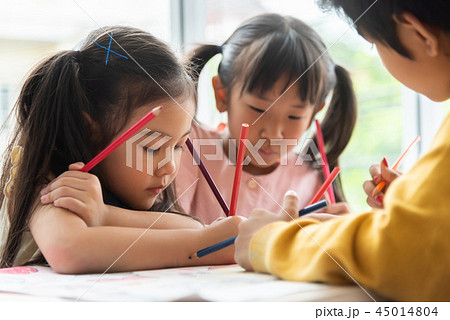 Asian little kids are colouring in a classroom. Asian little kids are colouring in a classroom. 45014804
