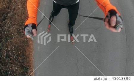 Training an athlete on the roller skaters. Biathlon ride on the roller skis with ski poles, in the 45018396