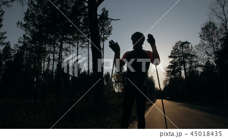 Training an athlete on the roller skaters. Biathlon ride on the roller skis with ski poles, in the Training an athlete on the roller skaters. Biathlon ride on the roller skis with ski poles, in the 45018435