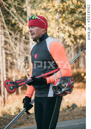Training an athlete on the roller skaters. Biathlon ride on the roller skis with ski poles, in the Training an athlete on the roller skaters. Biathlon ride on the roller skis with ski poles, in the 45018562