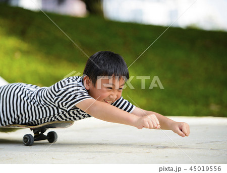 Little asian boy lying on a skateboard Little asian boy lying on a skateboard 45019556