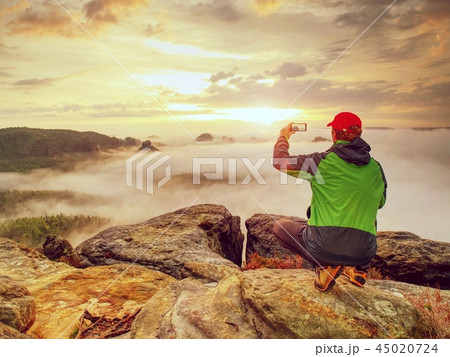 Courageous man on peak makes phone photo 45020724