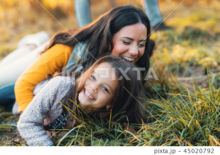 A portrait of young mother with a small daughter in autumn nature. A portrait of young mother with a small daughter in autumn nature. 45020792