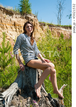 portrait of young beautiful woman on stump 45021532