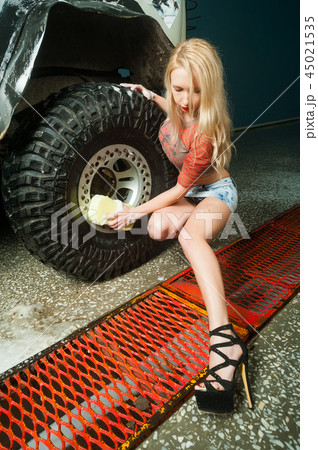Sexy young woman washing wheel of car Sexy young woman washing wheel of car 45021535