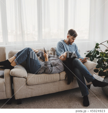 Couple in living room obsessed with smartphones Couple in living room obsessed with smartphones 45024923