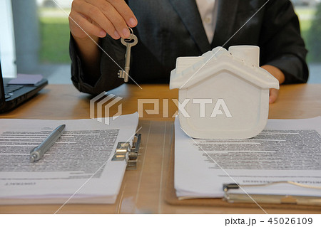 realtor agent with house model & key. buying renting real estate property. 45026109