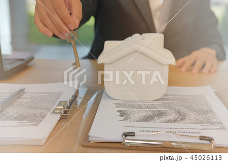 realtor agent with house model & key. buying renting real estate property. 45026113