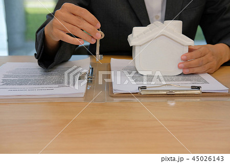 realtor agent with house model & key. buying renting real estate property. 45026143